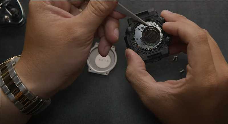 Xác định vị trí pin và tháo pin cũ ra khỏi đồng hồ